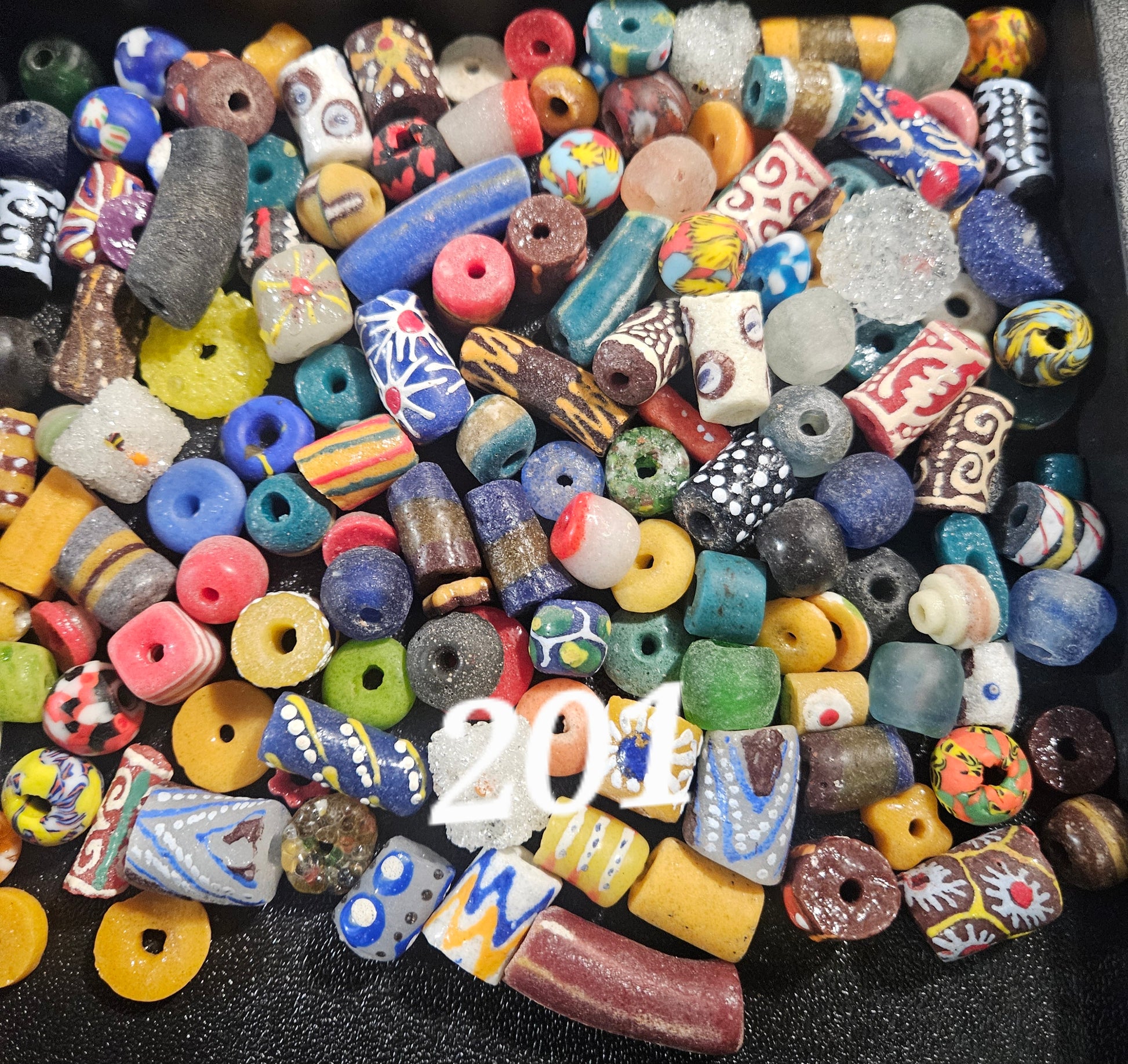Flat lay of assorted Krobo recycled glass beads from Ghana (~160 beads per scoop).