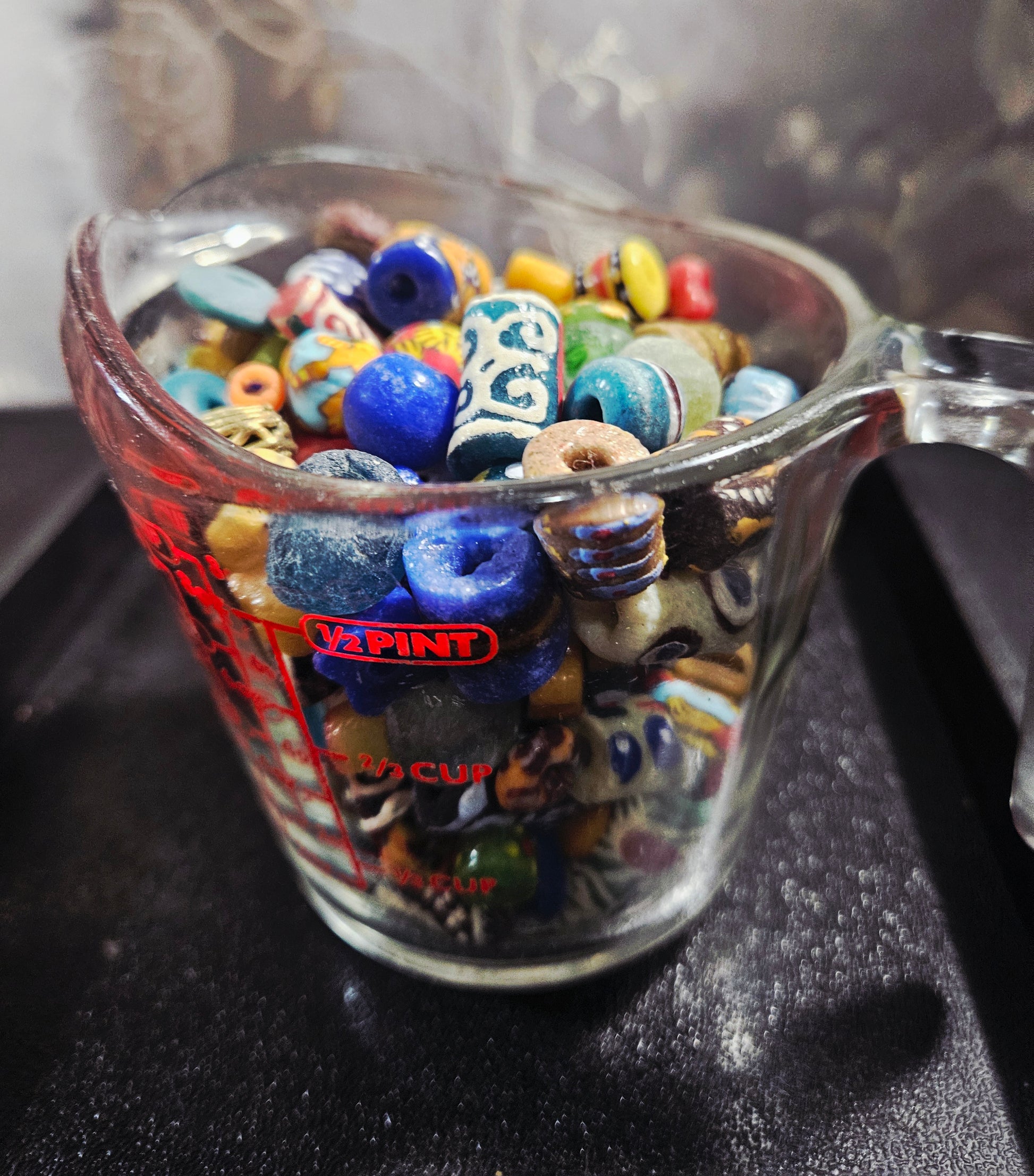 Measuring cup filled with speckled Krobo artisan beads.