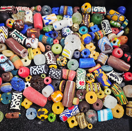Flat lay of speckled Krobo recycled glass beads with dotted surfaces.