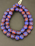 Authentic Fused Krobo recycled glass beads handcrafted in Ghana featuring royal blue and oxblood marbled patterns on approximately 44 artisan-made beads strung on a strand