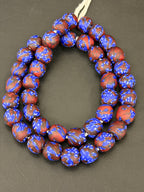 Authentic Fused Krobo recycled glass beads handcrafted in Ghana featuring royal blue and oxblood marbled patterns on approximately 44 artisan-made beads strung on a strand