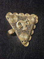 Close view of the wide textured brass bail on a handcrafted Sankofa Adinkra pendant from Ghana.