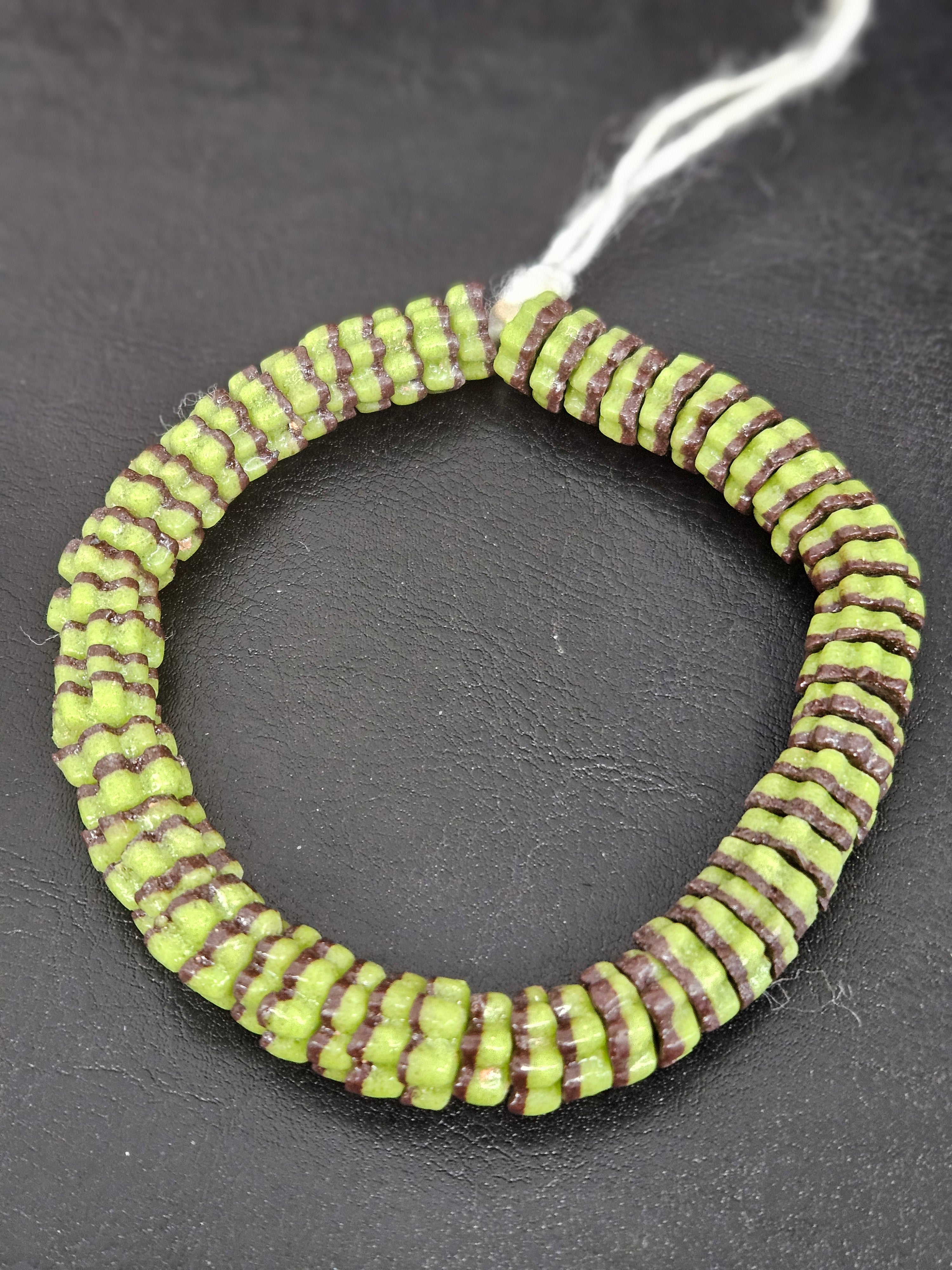 Handcrafted spring green and cocoa brown Krobo glass spacer beads from Ghana featuring recycled glass artisan craftsmanship and striped spacer-bead design.