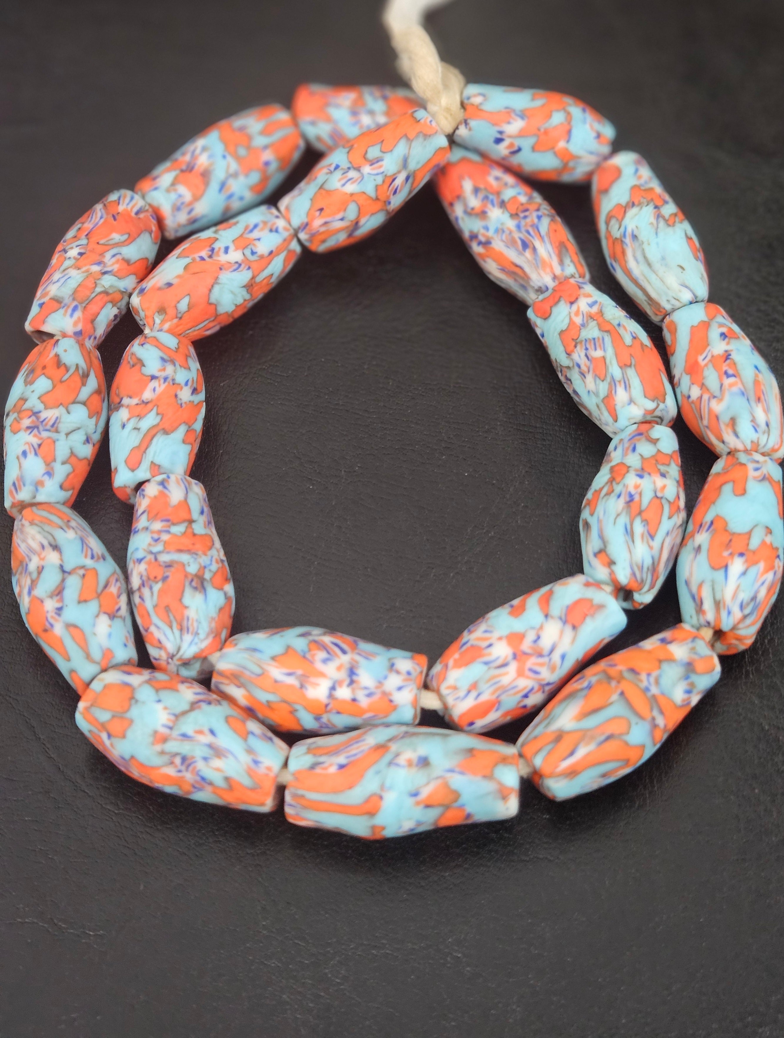 Handcrafted XL orange fused Krobo recycled glass beads from Ghana featuring artisan ivory and charcoal patterns, approximately 12–14mm x 30–34mm.