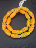 Handcrafted XL orange fused Krobo recycled glass beads from Ghana featuring golden-yellow and charcoal patterns, approximately 12–14mm x 30–34mm.